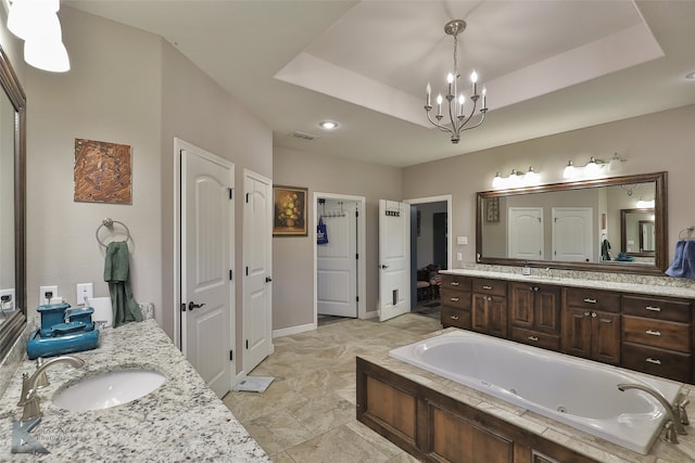 bathroom featuring vanity, a bathing tub, and a raised ceiling