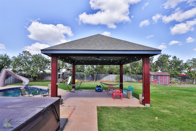 view of patio / terrace with a fenced in pool, a gazebo, and a storage shed