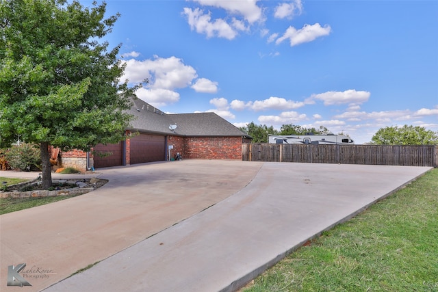 exterior space featuring a garage and a lawn