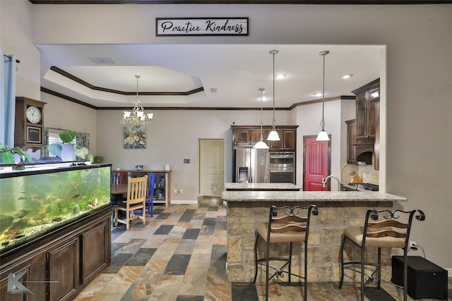 kitchen featuring stainless steel appliances, a breakfast bar, pendant lighting, a chandelier, and ornamental molding