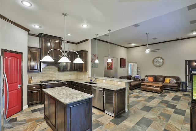 kitchen featuring sink, stainless steel appliances, kitchen peninsula, hanging light fixtures, and a center island