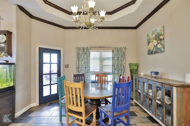 dining room with a notable chandelier, a tray ceiling, and ornamental molding