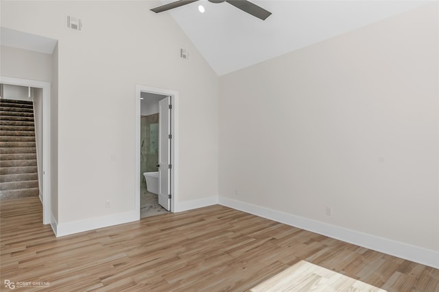 unfurnished bedroom with ceiling fan, connected bathroom, light hardwood / wood-style floors, and high vaulted ceiling