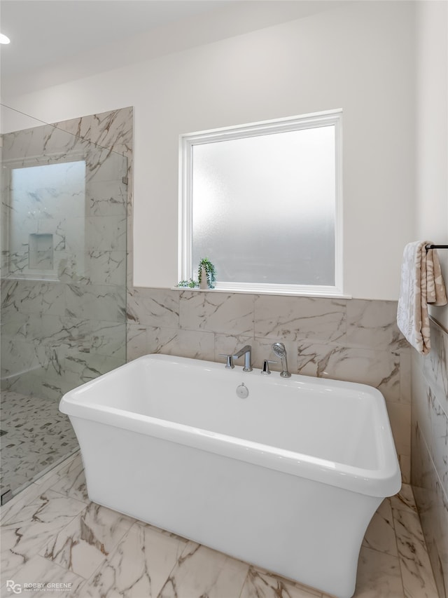 bathroom with tile walls and separate shower and tub