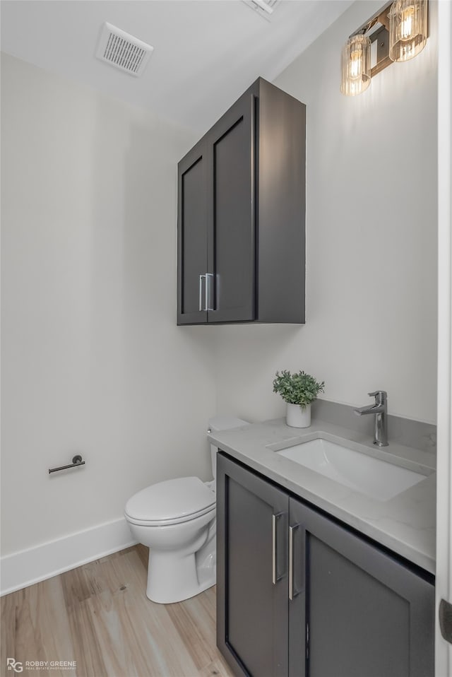 bathroom with vanity, hardwood / wood-style floors, and toilet