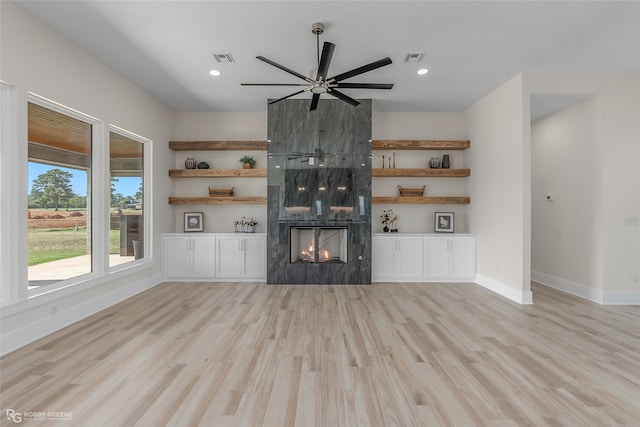 unfurnished living room with a fireplace, ceiling fan, and light hardwood / wood-style flooring