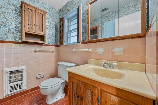 bathroom featuring vanity, tile patterned floors, toilet, tile walls, and heating unit