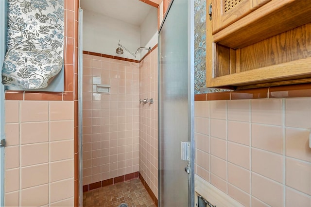 bathroom with an enclosed shower and tile walls