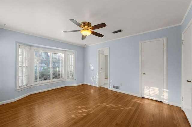 empty room with hardwood / wood-style floors, ceiling fan, and ornamental molding