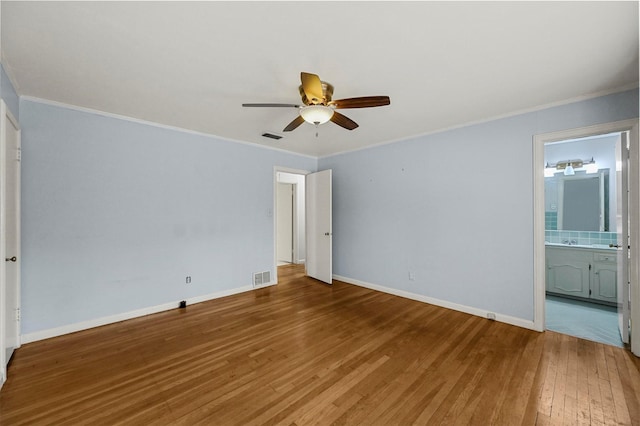 unfurnished bedroom featuring ensuite bathroom, ceiling fan, hardwood / wood-style flooring, and ornamental molding