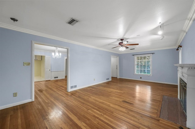 unfurnished living room featuring a fireplace, wood-type flooring, ceiling fan with notable chandelier, and crown molding