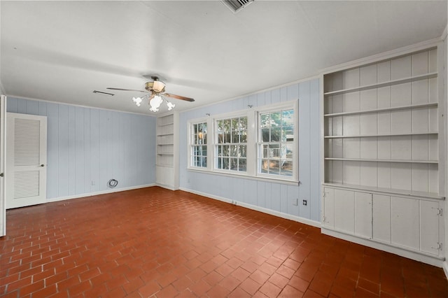 unfurnished room featuring built in shelves, ceiling fan, and ornamental molding