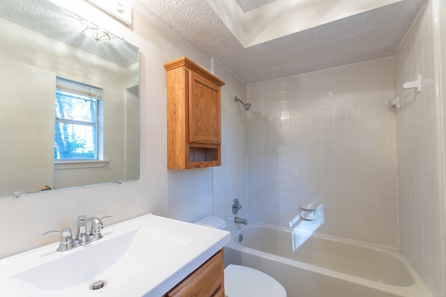 full bathroom with vanity, tiled shower / bath combo, a textured ceiling, and toilet