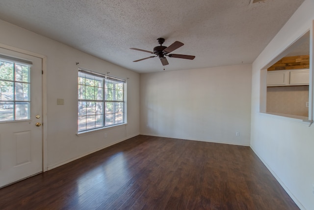 unfurnished room with ceiling fan, dark wood-type flooring, and a textured ceiling