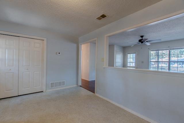 empty room featuring ceiling fan and a textured ceiling