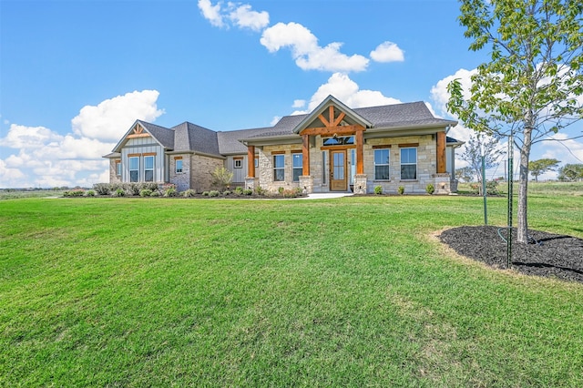 craftsman house featuring stone siding, covered porch, board and batten siding, and a front yard