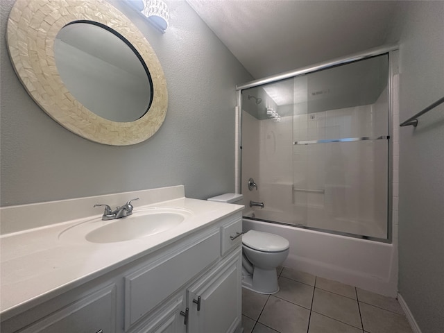 full bathroom featuring combined bath / shower with glass door, tile patterned flooring, toilet, and vanity