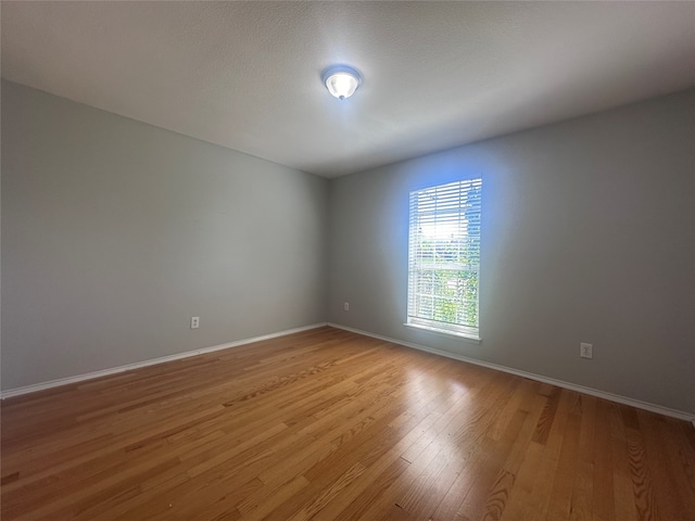 unfurnished room featuring light hardwood / wood-style flooring and a textured ceiling