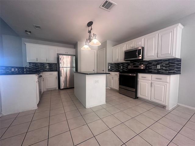 kitchen with a kitchen island, decorative backsplash, hanging light fixtures, appliances with stainless steel finishes, and white cabinetry