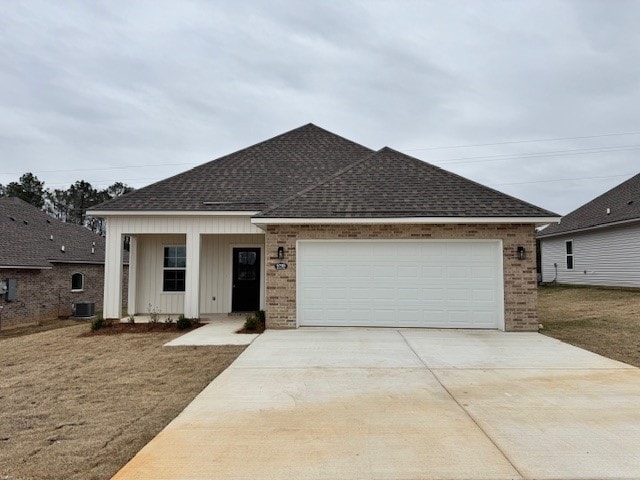 view of front of house with a garage, brick siding, concrete driveway, and roof with shingles