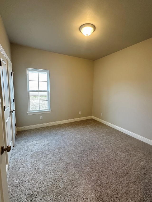 empty room featuring baseboards and carpet flooring