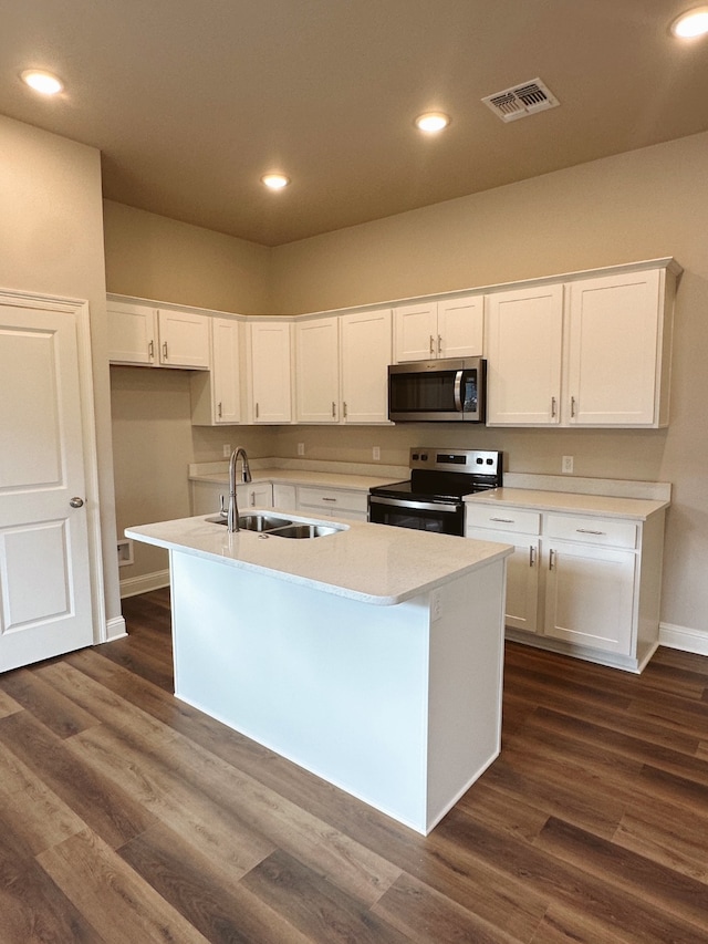 kitchen with an island with sink, sink, white cabinets, and electric stove