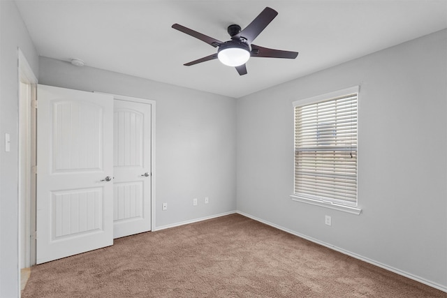 unfurnished bedroom with a closet, light carpet, and ceiling fan