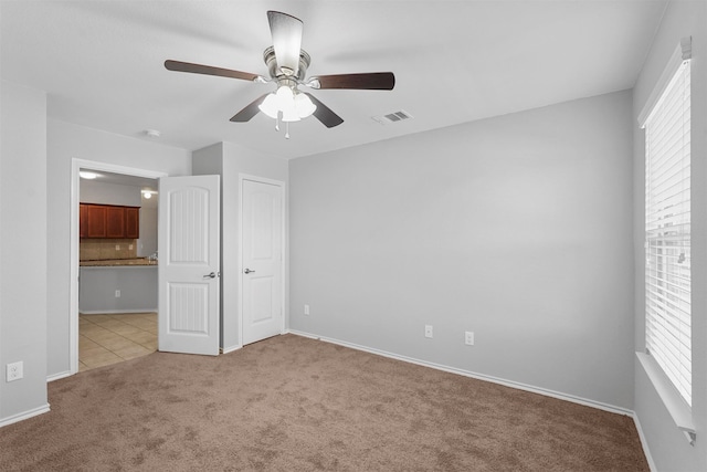 unfurnished bedroom with light carpet and ceiling fan