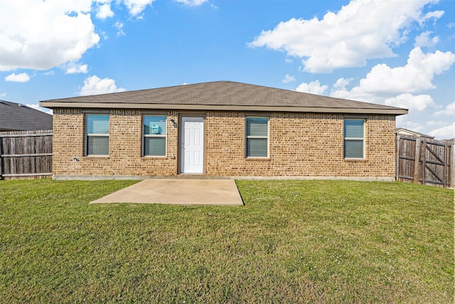 rear view of property featuring a yard and a patio area