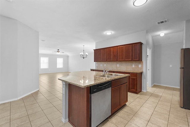 kitchen with light tile patterned flooring, decorative backsplash, a kitchen island with sink, ceiling fan with notable chandelier, and stainless steel appliances