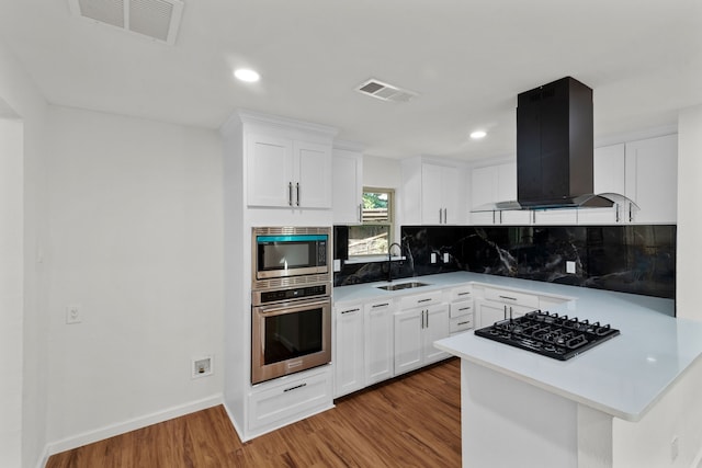 kitchen featuring white cabinetry, sink, stainless steel appliances, light hardwood / wood-style floors, and exhaust hood