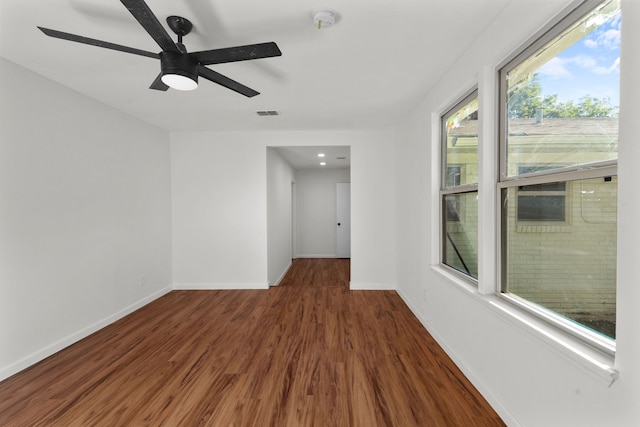 spare room with dark hardwood / wood-style floors and ceiling fan