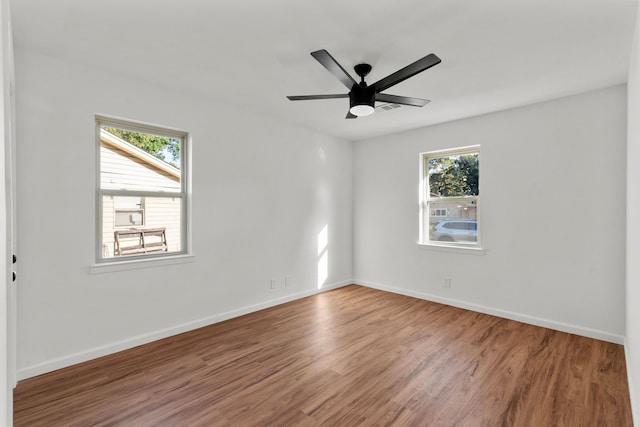 unfurnished room with ceiling fan, a healthy amount of sunlight, and wood-type flooring