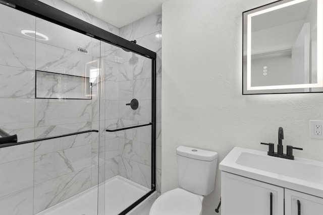 bathroom featuring vanity, toilet, and a shower with door