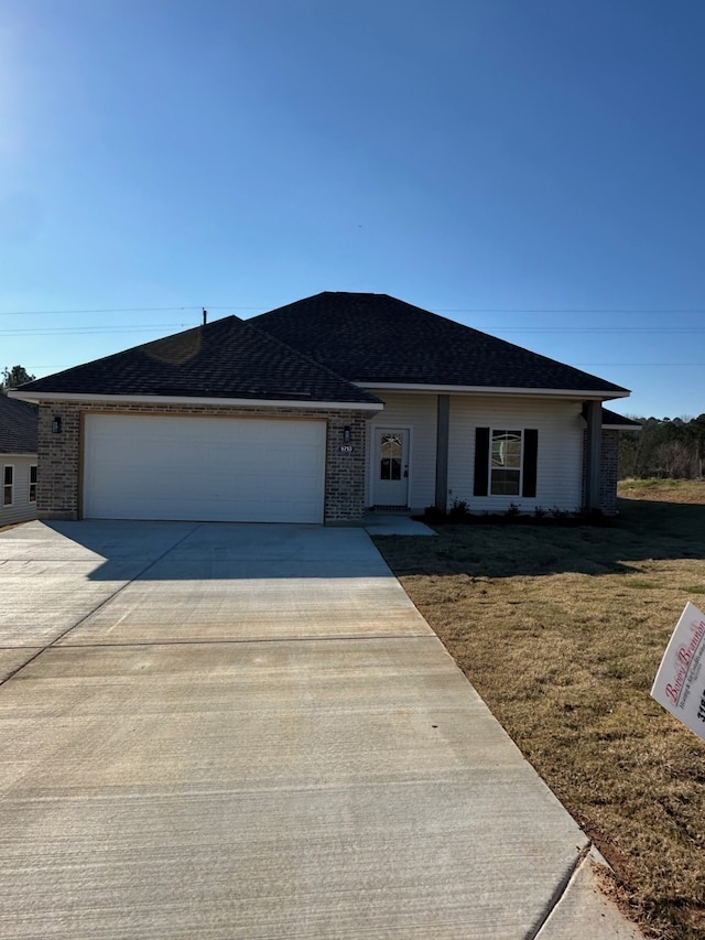 ranch-style house with a front yard and a garage