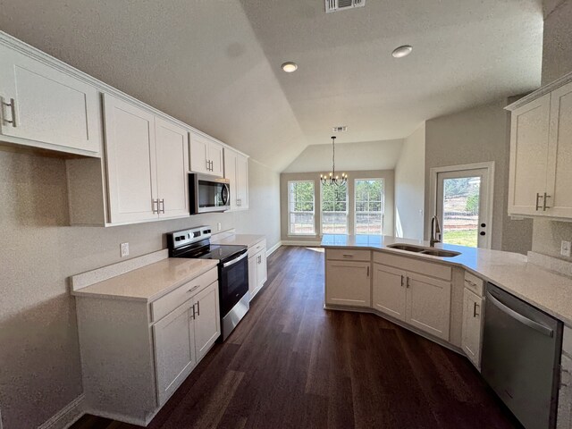 5793 Bunker Way, Blanchard, LA 71107 - kitchen with a peninsula, a sink, vaulted ceiling, appliances with stainless steel finishes, and dark wood-style floors