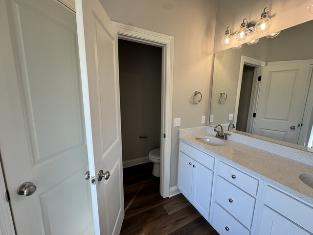 5793 Bunker Way, Blanchard, LA 71107 - full bathroom with double vanity, toilet, a sink, wood finished floors, and baseboards