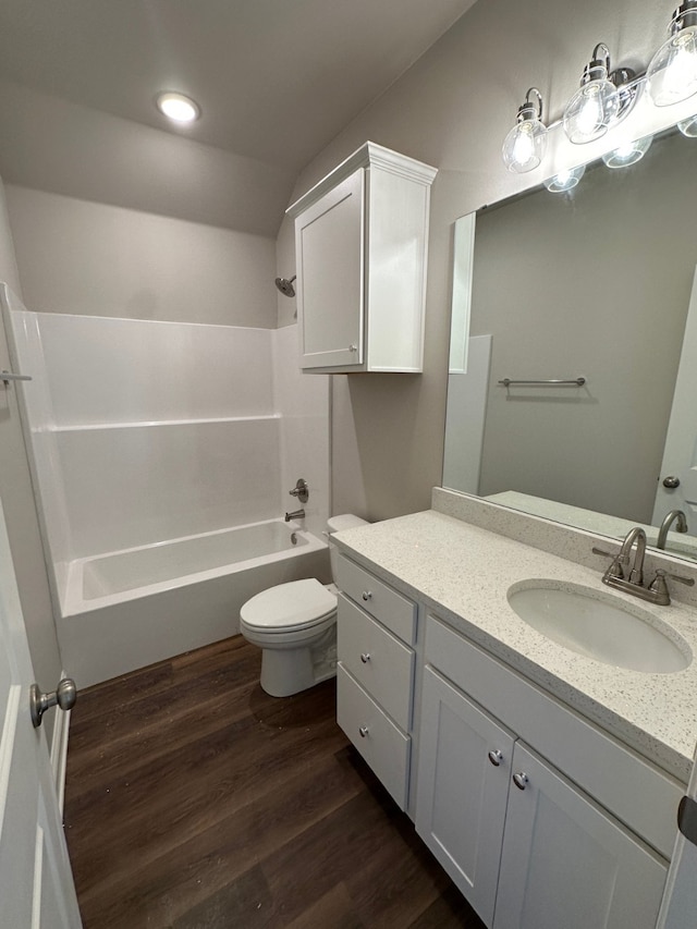 full bathroom with washtub / shower combination, hardwood / wood-style floors, vanity, and toilet