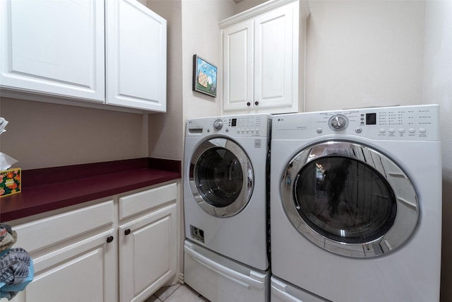 laundry area with light tile patterned flooring, cabinets, and washing machine and dryer