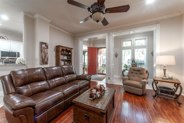 living room with dark hardwood / wood-style flooring, ceiling fan, and ornamental molding