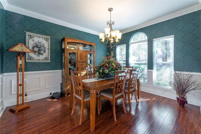 dining area featuring dark hardwood / wood-style flooring, crown molding, and an inviting chandelier