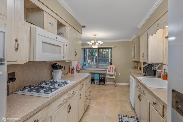 kitchen with a chandelier, white appliances, crown molding, sink, and hanging light fixtures