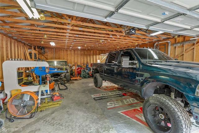 garage with a garage door opener and wooden walls