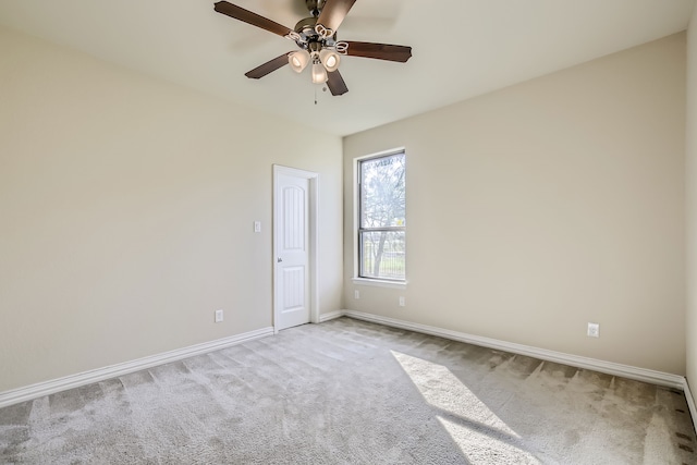 carpeted spare room featuring ceiling fan