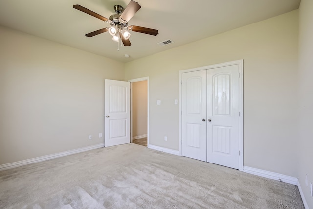 unfurnished bedroom with light carpet, a closet, and ceiling fan