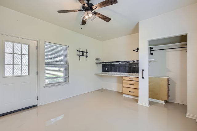 interior space with ornate columns, a closet, multiple windows, and ceiling fan