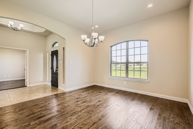 unfurnished dining area with light hardwood / wood-style floors and an inviting chandelier