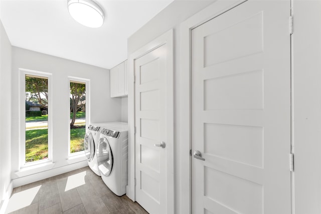 washroom featuring hardwood / wood-style flooring, cabinets, and independent washer and dryer