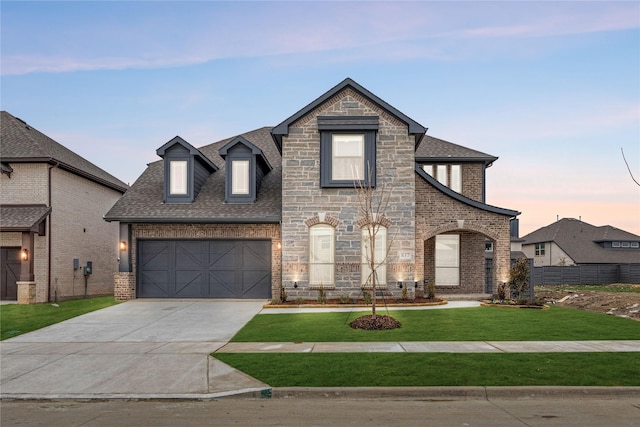 french country inspired facade featuring a garage and a lawn