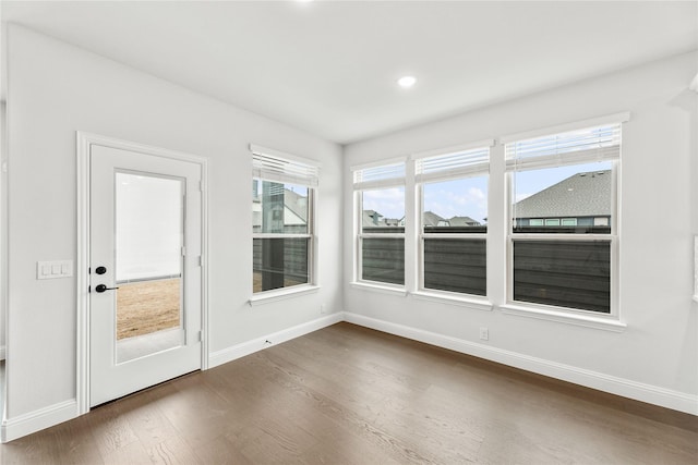 unfurnished sunroom featuring dark hardwood / wood-style floors